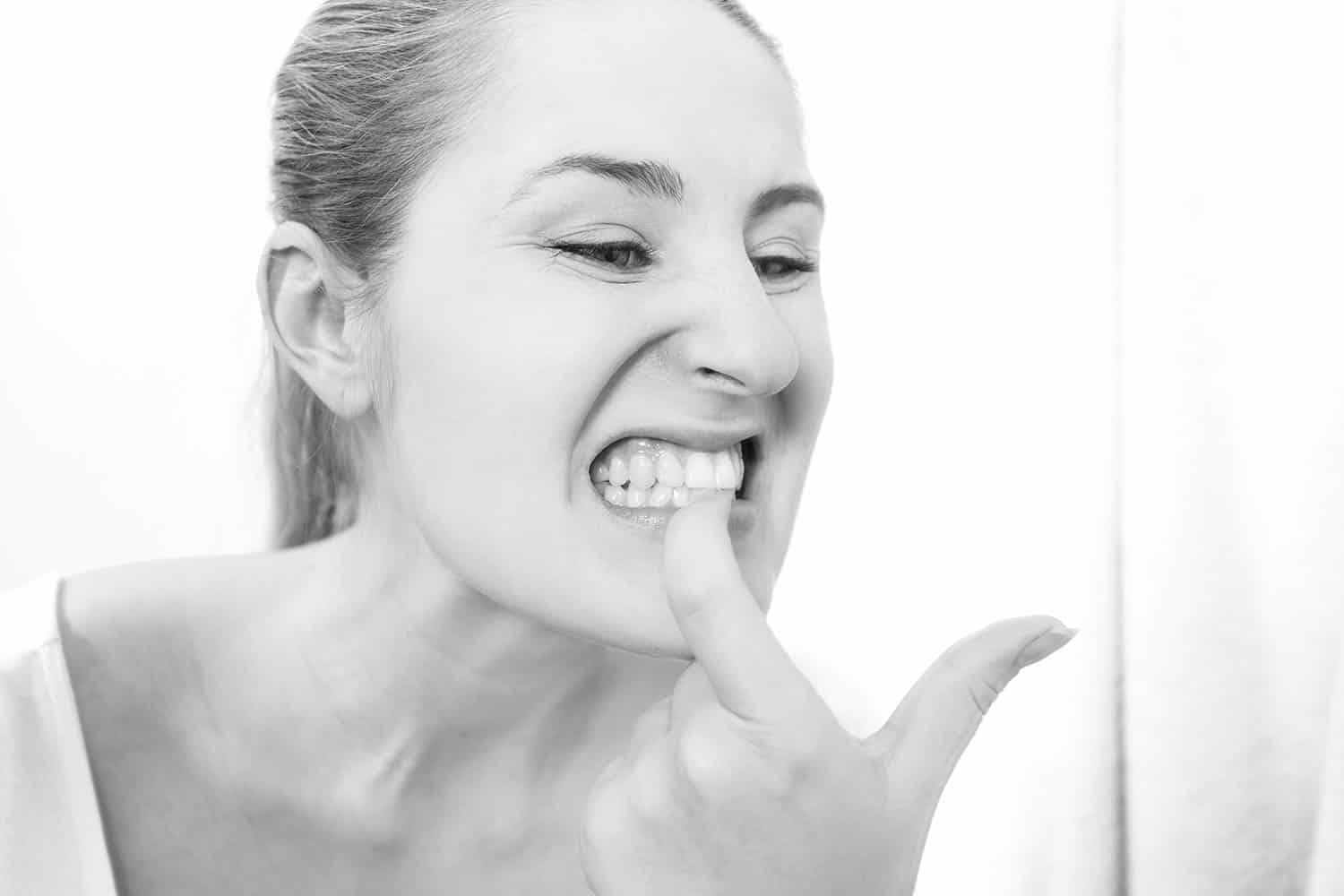 woman pointing to her bleeding gums