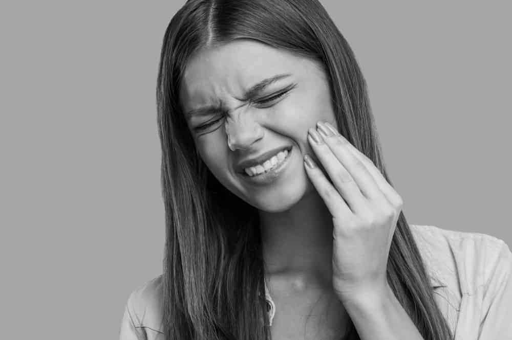 girl with her hand over hew jaw