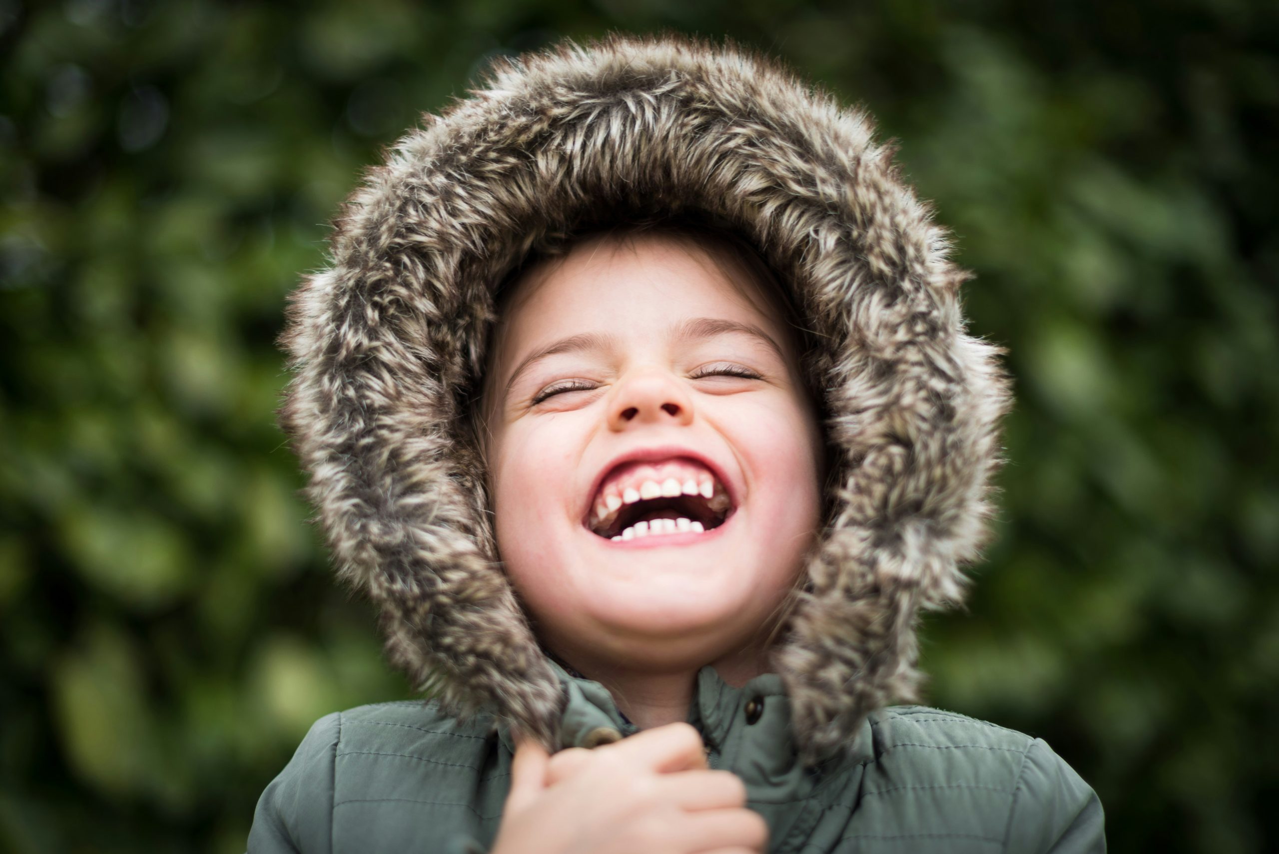 Child laughing with many teeth showing.