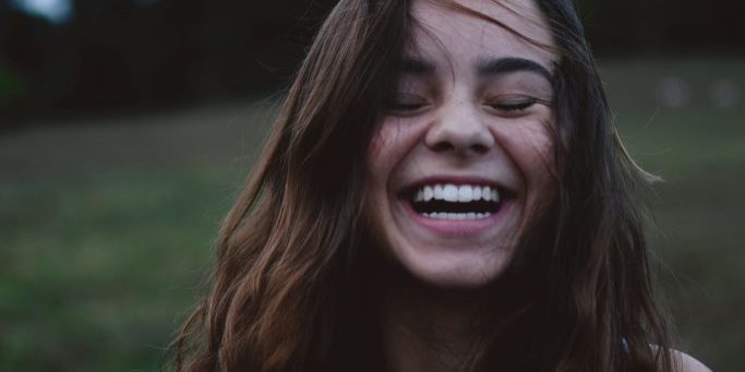 A girl smiling with her eyes closed.